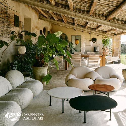 Rustic outdoor patio with cozy seating, wooden furniture, plants, and hammock.