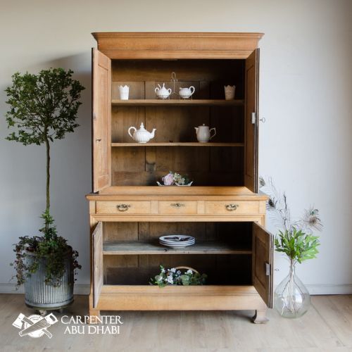 Vintage wooden cabinet with decorative teaware.